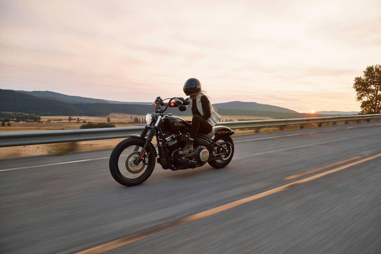 A rider on a black motorcycle at dusk